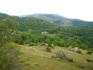 a grassy hill with a house in the distance at Tente style Tepee Confort in Latour-de-Carol