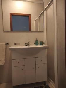 a bathroom with a sink and a mirror at Casa dos Rosas in Melides