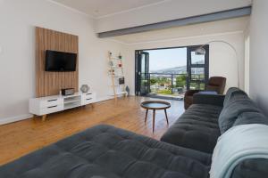 a living room with a couch and a tv at Albert Road 14 in Cape Town