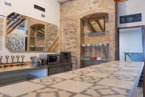 cocina con pared de piedra y encimera en HOSTEL PRIME, en Benicàssim
