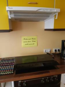 a yellow sign on a wall above a stove at Ferienwohnung am Spreeradweg in Neusalza-Spremberg