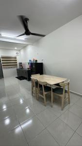 a wooden table and chairs in a room at AZALiA HOMESTAYMUSLIM TELUK INTAN in Teluk Intan