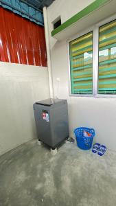 a water heater in a room with two blue sandals at AZALiA HOMESTAYMUSLIM TELUK INTAN in Teluk Intan