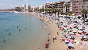 a group of people on a beach with umbrellas at HDA apartment 2. in Torrevieja