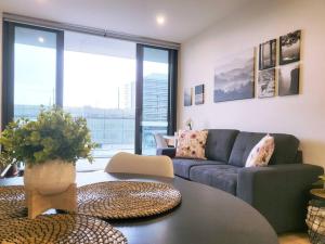 a living room with a couch and a table at Cityscape Lovely 1BR Apt & Parking @CBD in Canberra