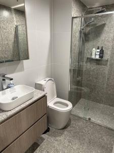 een badkamer met een toilet, een wastafel en een douche bij Cityscape Lovely 1BR Apt & Parking @CBD in Canberra