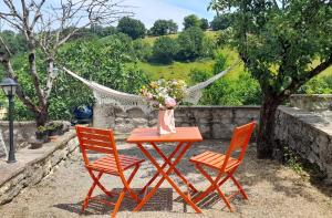 een tafel met twee stoelen en een vaas met bloemen erop bij Ferme de Lacassagne in Vazerac