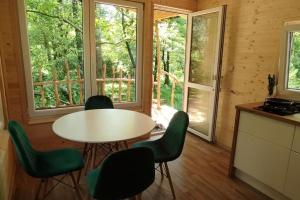 a dining room with a table and green chairs at Treehouse LEA in Mikulášovice