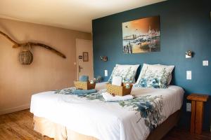 a bedroom with a bed with two baskets on it at Les Volets Violets in Salles