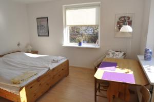 1 dormitorio con cama, escritorio y ventana en Guesthouse Højland en Ry