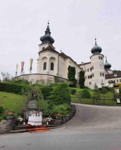 un gran edificio blanco con una torre en una colina en Urlaub in Schlossnähe, en Artstetten