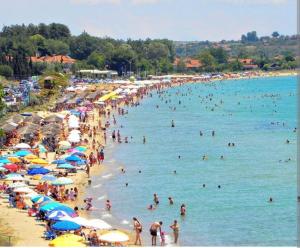 a crowded beach with a lot of people in the water at Persefoni 's hause 1 in Nea Kalikratia