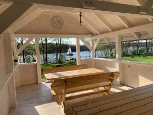 a porch with a wooden table and benches at MAŁY PORT-Iława - Jezioro - Plaża - Marina priv - 5 pokoi VIP - czysto na 10 in Iława