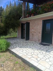 a house with two doors and a stone driveway at Blondie's House in Evropoúloi