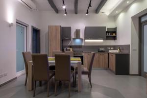 a kitchen and dining room with a table and chairs at Harbour Haven Maisonette in Kalkara