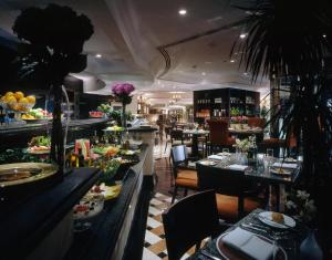 un restaurante con una línea de buffet con mesas y sillas en Sheraton Khalidiya Hotel, en Abu Dabi