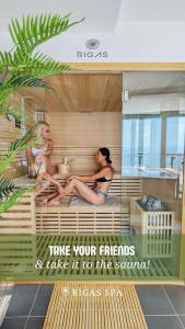 two women sitting in a sauna in a building at Rigas Boutique Hotel & Spa in Afitos
