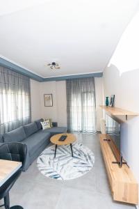 ein Wohnzimmer mit einem Sofa und einem Tisch in der Unterkunft Stylish Urban Getaway by thesbnb in Thessaloniki