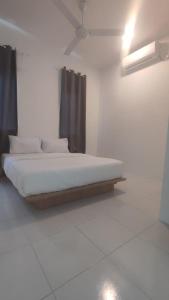 a bed in a white room with a ceiling at Gopeng Senada Holiday House in Gopeng
