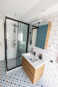 ein Bad mit einem Waschbecken und einer Dusche in der Unterkunft Stylish Urban Getaway by thesbnb in Thessaloniki