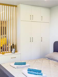 a bedroom with white cabinets and blue towels on a bed at Lemon Tree Villa in Chalkida