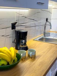 un tazón de plátanos en una barra de cocina con cafetera en Lemon Tree Villa, en Chalkida