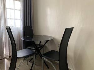 a small table and chairs in a room with a window at CASILINA GUEST HOME in Limbe