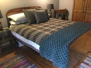 una camera da letto con un letto con una coperta blu sopra di Holly cottage Wold Newton, near Yorkshire coast a Wold Newton