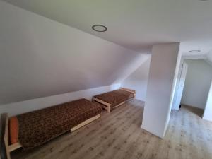 Cette chambre mansardée comprend 2 lits. dans l'établissement Domek na uboczu 3 pokoje 2 łazienki i taras, à Cracovie