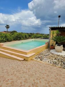 une grande piscine entourée de marches. dans l'établissement Casa Falconara, à Noto Marina