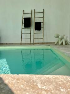 a swimming pool with two chairs and a towel rack at Manoir Les Feuillantines Piscine & Spa in Isques