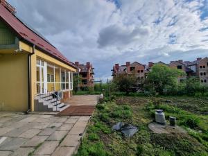 une maison avec une terrasse couverte et une cour avec des maisons dans l'établissement Domek na uboczu 3 pokoje 2 łazienki i taras, à Cracovie