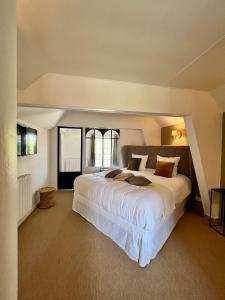 a bedroom with a large white bed and a window at Manoir Les Feuillantines Piscine & Spa in Isques