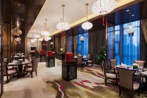Dangtu的住宿－馬鞍山萬達嘉華酒店，用餐室配有桌椅和吊灯。