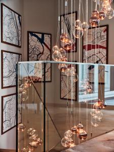 une table en verre avec des lumières dans une pièce ornée de peintures dans l'établissement Holiday Inn Gdansk - City Centre, an IHG Hotel, à Gdańsk