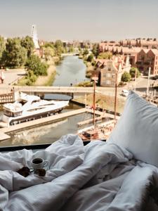 a bed with a cup of coffee and a view of a river at Holiday Inn Gdansk - City Centre, an IHG Hotel in Gdańsk
