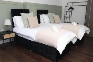 a bedroom with two beds with white pillows at Watford Luxury 1 Bed Flat - Free Parking in Watford