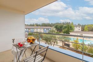 un balcone con tavolo e sedie e vista di Appart'City Classic Bordeaux Aéroport St Jean D'Illac a Saint-Jean-d'Illac Altre 34 foto