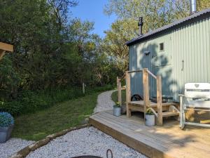 a bench sitting on a wooden ramp next to a building at Shepherds Hut with Hot Tub in Fryup