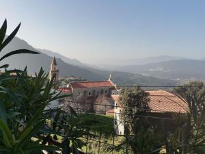 a building with a church and a mountain in the background at Entre Mer et Montagne in Sartène