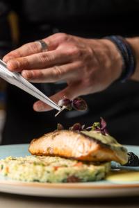 una persona sosteniendo un cuchillo y un tenedor y un plato de comida en Rigas Boutique Hotel & Spa, en Afitos