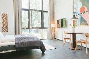 1 dormitorio con cama, mesa y ventana en The Forest apartments by Daniel&Jacob's, en Kongens Lyngby