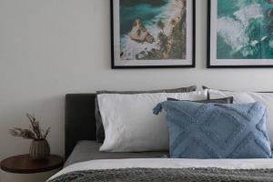 um quarto com uma cama com almofadas e fotografias na parede em The Nines em Wollongong