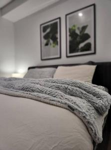 um cobertor deitado em cima de uma cama com duas fotografias em The Nines em Wollongong