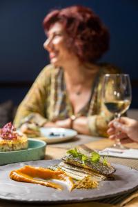 a woman sitting at a table with a glass of wine at Rigas Boutique Hotel & Spa in Afitos