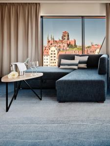 a living room with a couch and a table at Holiday Inn Gdansk - City Centre by IHG in Gdańsk +276 photos