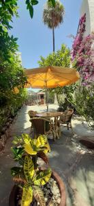 um pátio com uma mesa, cadeiras e um guarda-sol em Alsol El Chaparral em Playa del Inglés