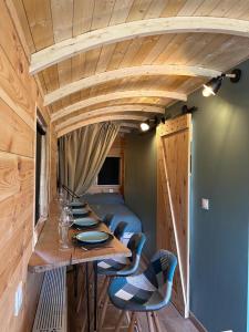 a dining room with a long table and chairs at La Roulotte de Loïs & Clara in Arc-en-Barrois