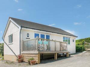 a small white house with a wooden deck at Gwel An Koos in Bodmin