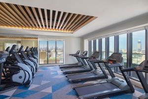 un gimnasio con equipo cardiovascular en una habitación de hotel con ventanas en Element Al Jaddaf, Dubai, en Dubái